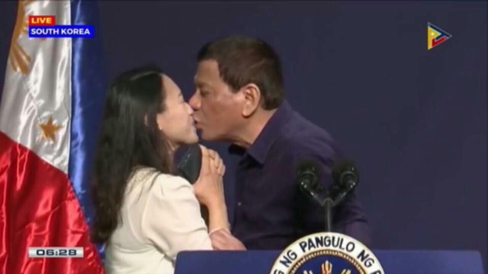 Filipijnse president Rodrigo Duterte door het stof nadat hij vrouw overtuigt hem op de mond te kussen