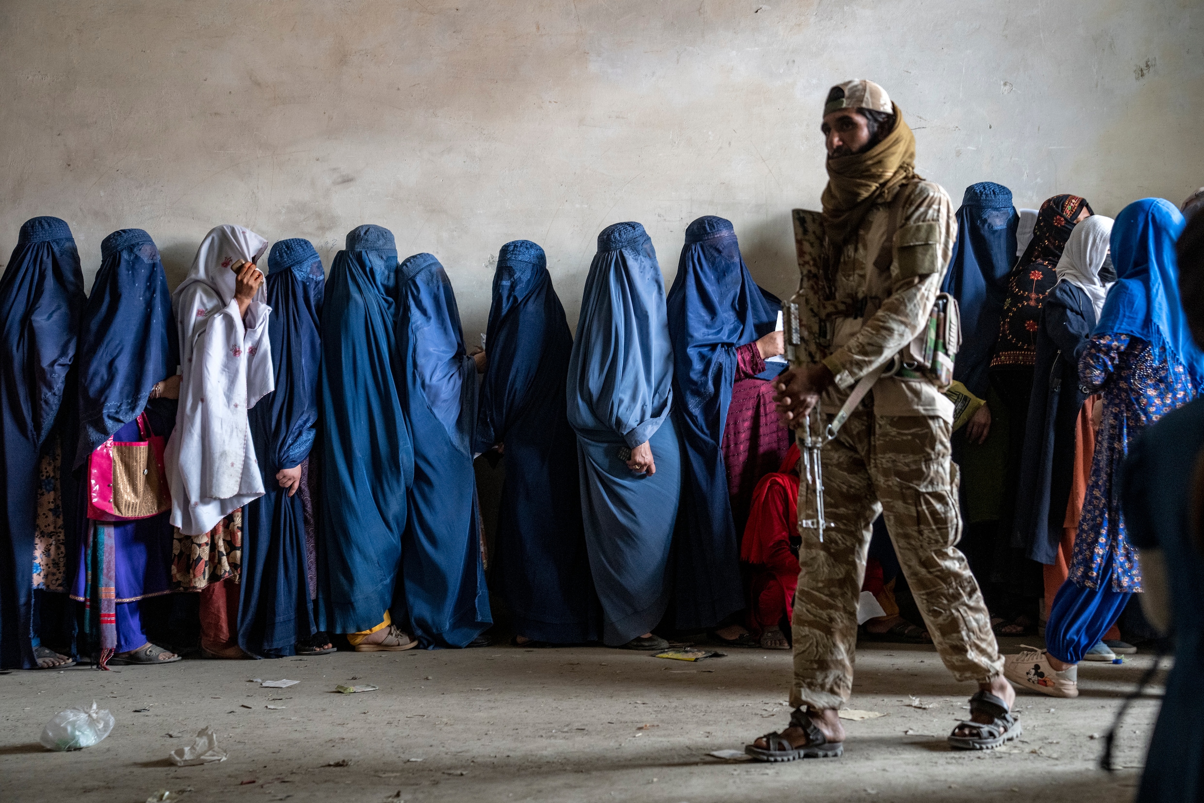 een-talibanstrijder-in-kaboel-houdt-de-wacht-terwijl-gesluierde