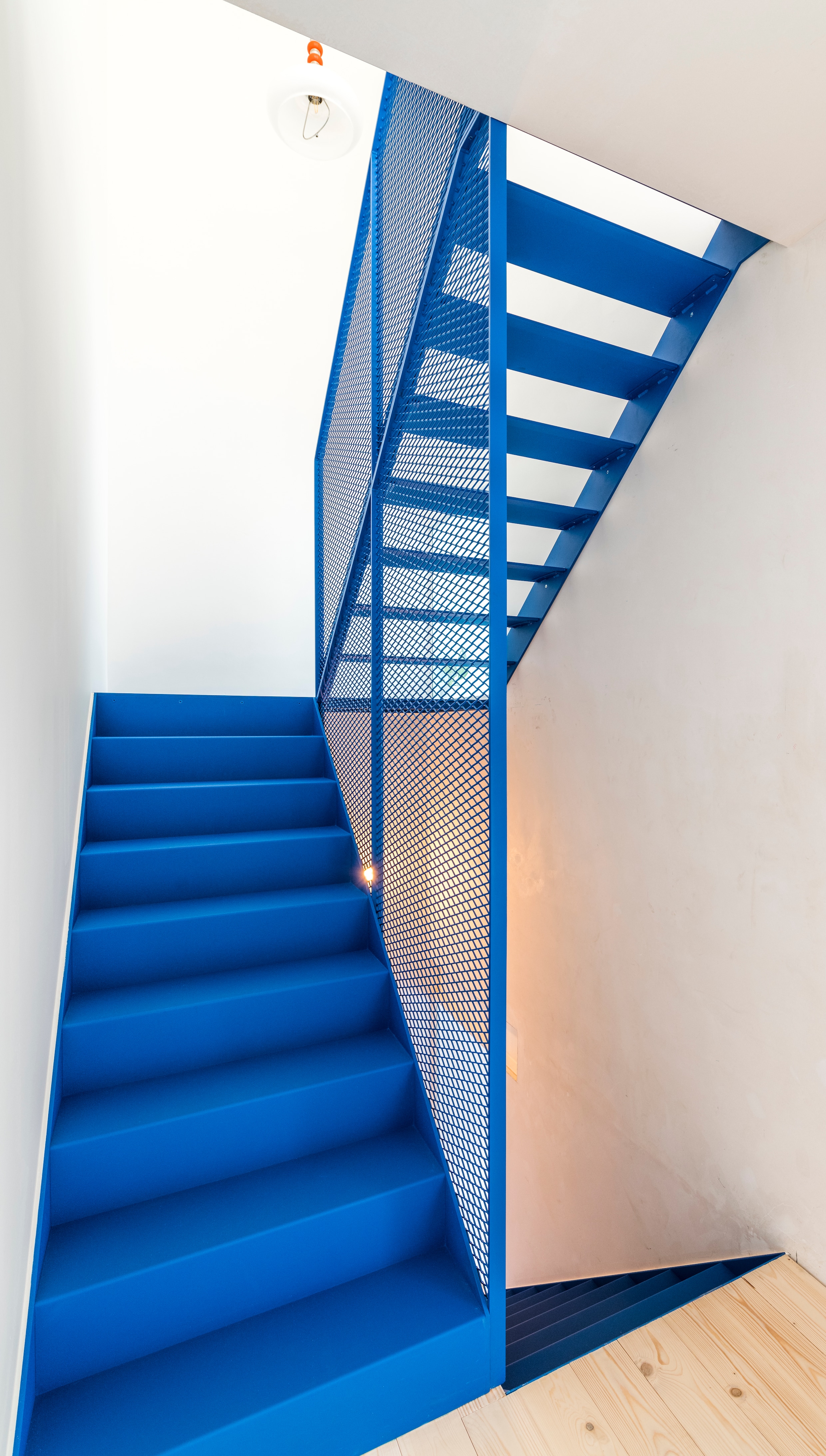 De oude trap die vroeger tegen de zijgevel stond, werd vervangen door een blikvanger van azuurblauw metaal.