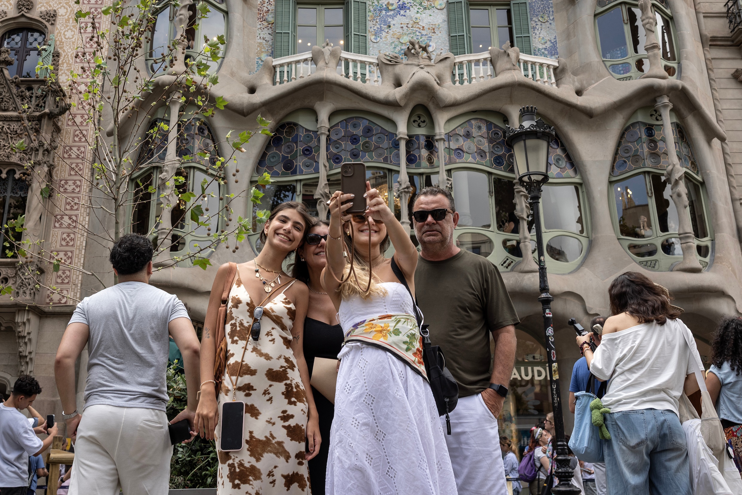 Toeristen nemen een selfie bij Casa Batllo, een gebouw ontworpen door Antoni Gaudí in Barcelona.