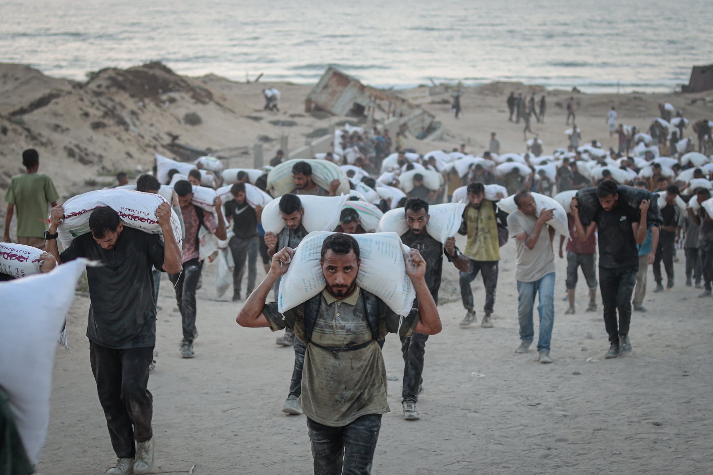 Palestijnen die een zak bloem hebben weten te bemachtigen, brengen die naar hun families.