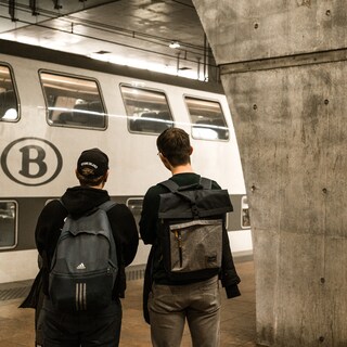 NMBS-trein op Belgisch station met reizigers die instappen
