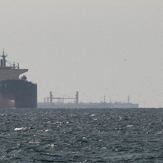 Olietanker vaart door de smalle Straat van Hormuz met op de achtergrond de kust van Iran