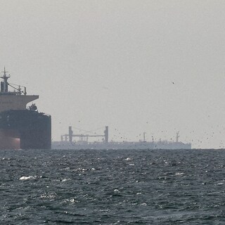 Olietanker vaart door de smalle Straat van Hormuz met op de achtergrond de kust van Iran