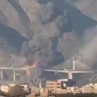 Rookwolken boven een stad na luchtaanvallen, symbolisch voor het conflict tussen de VS en Iran