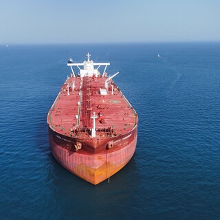 Olietankers varen door de Straat van Hormuz met Iran op de achtergrond