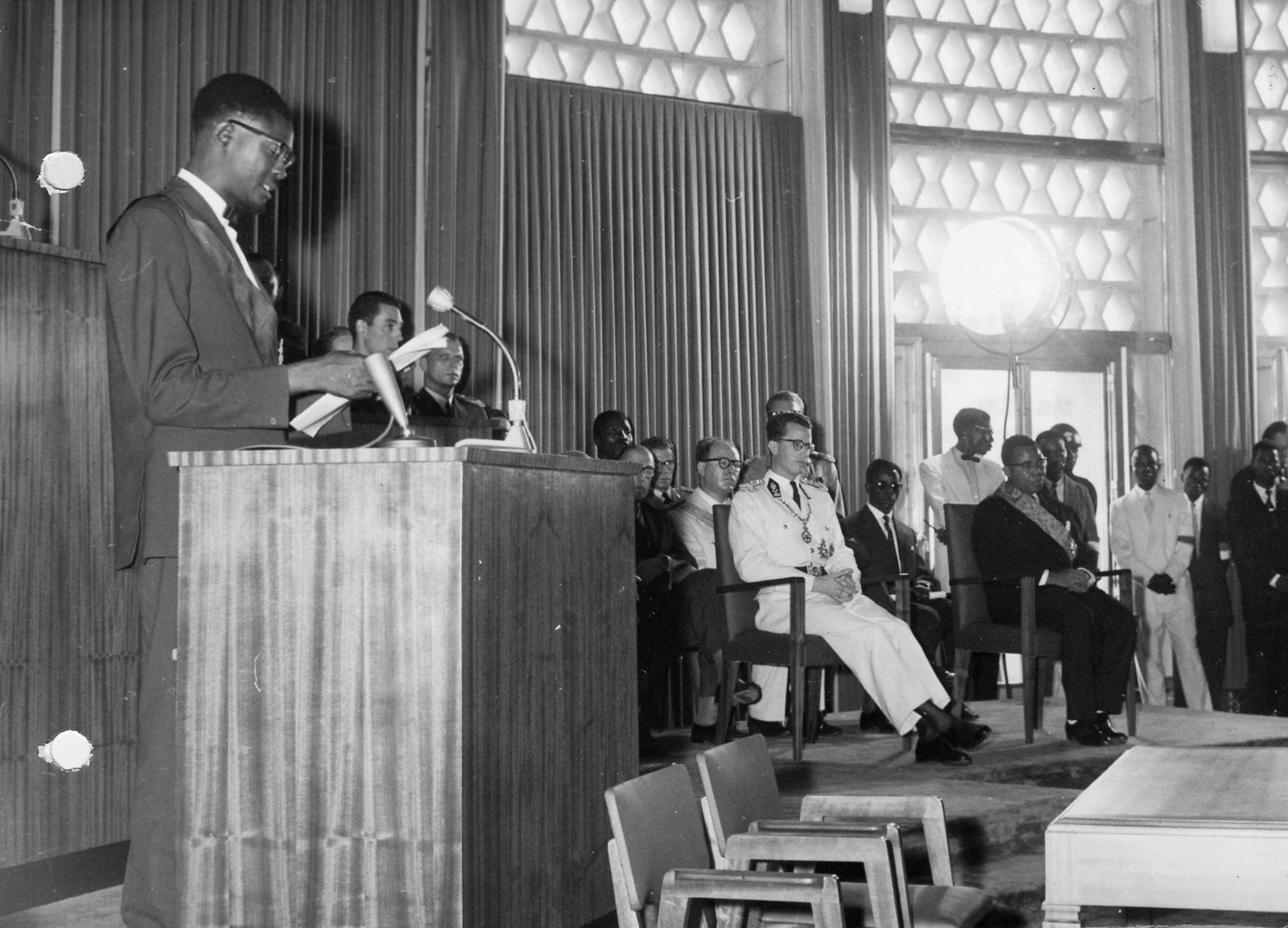 Onaangekondigd bestijgt premier Patrice Lumumba op 30 juni 1960 het spreekgestoelte. Koning Boudewijn (in het wit), die even eerder nog 'het genie van Leopold II' prees, weet niet wat er gebeurt.